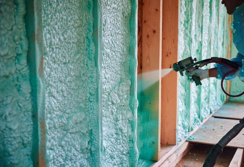 builder-spraying-foam-insulation-on-wooden-house